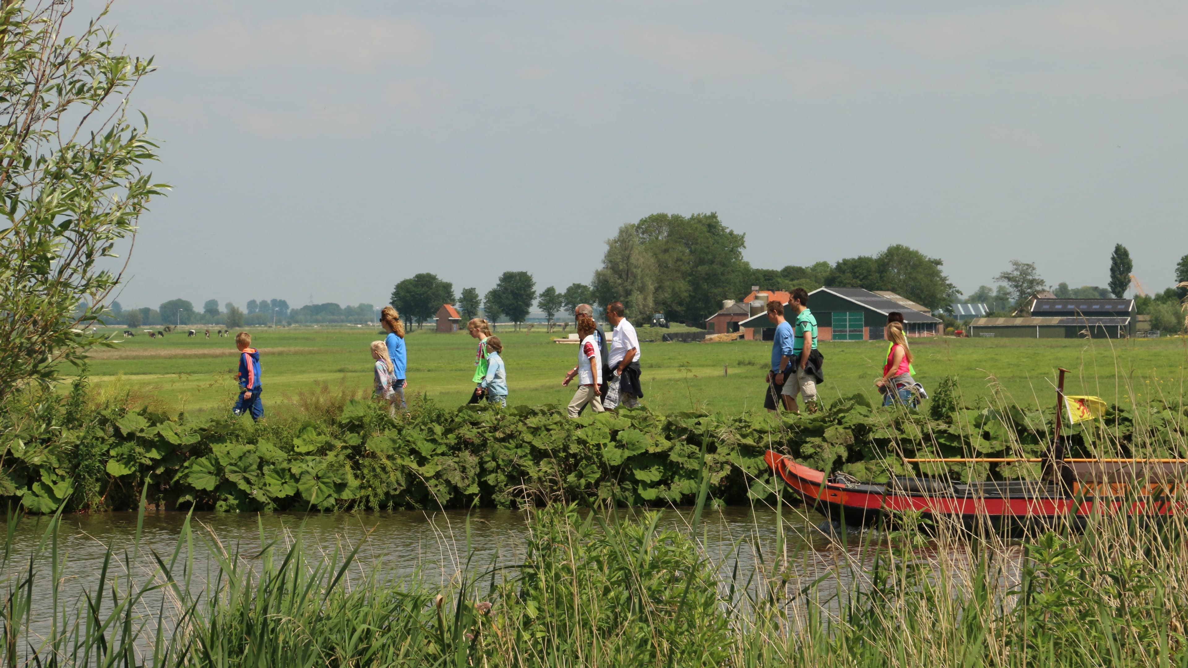 Een groep mensen die wandelen over een hoge kade.